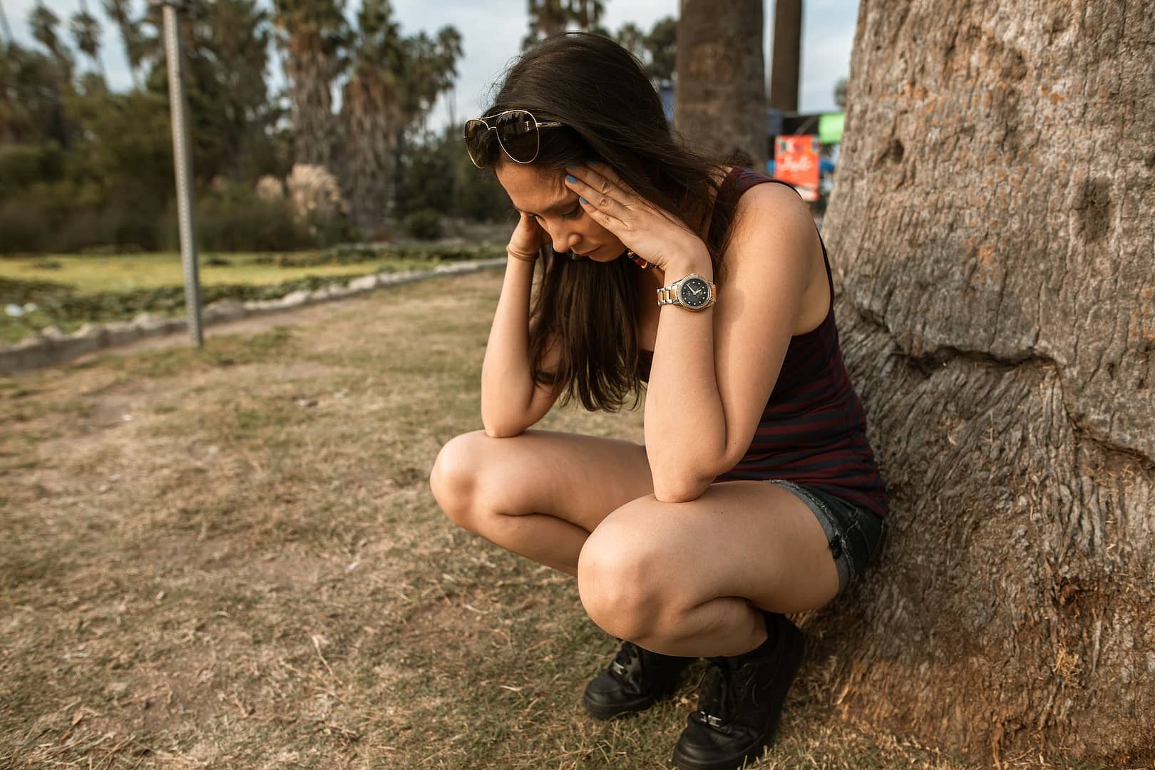 Anxiety and depression - photo of a woman crouching while her hands are on her head