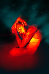 woman sitting on the floor with her hands on head