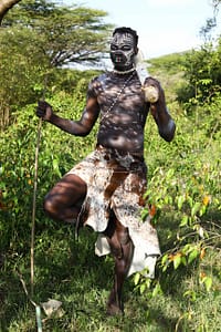 man wearing animal skin clothing and having his body painted