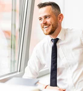 smiling man wearing a shirt and tie
