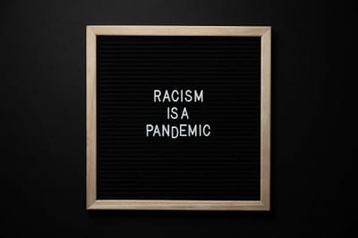 phrase racism is pandemic on signboard