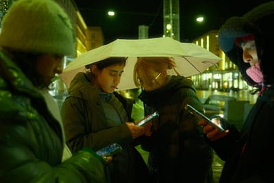 night street scene with friends under umbrella