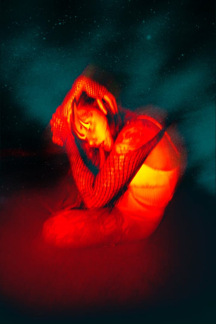 woman sitting on the floor with her hands on head