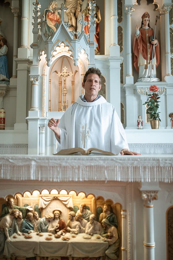 a priest preaching inside the church