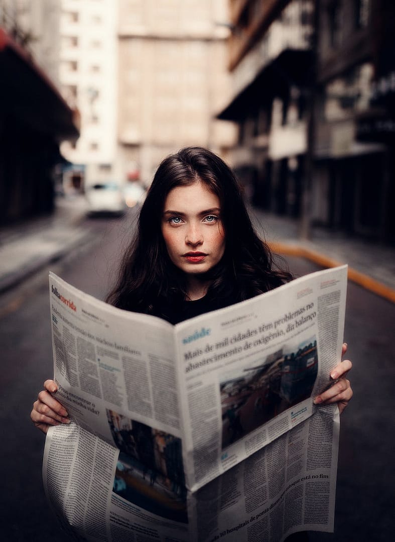 woman in gray sweater holding white newspaper - Time To Get Murdoch Press Out Of Australia